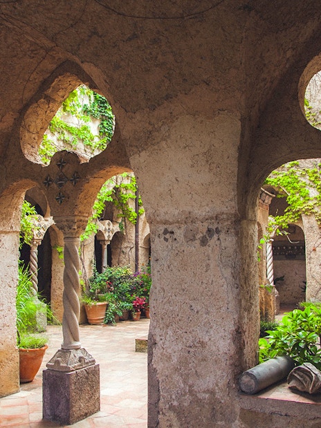Medieval cloister with arches and greenery, Amalfi Coast.
