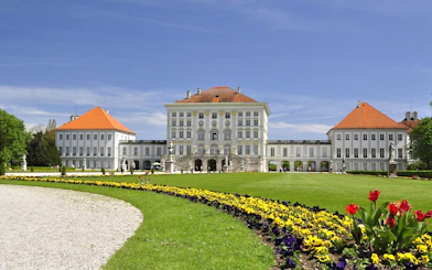 Nymphenburg Palace in Munich with gardens and colorful flowers.