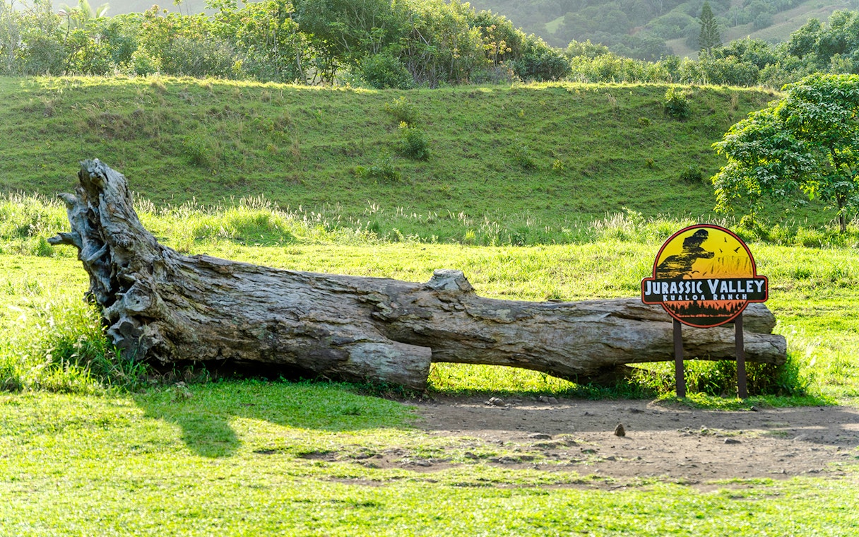 Jurassic Valley sign and fallen log at Kualoa Ranch, Hawaii.