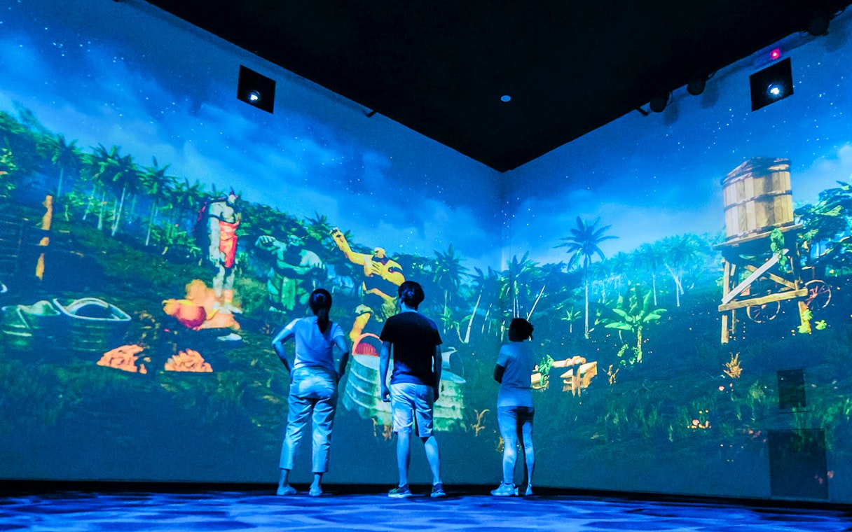 Visitors experience local legends through projection mapping in an immersive room.