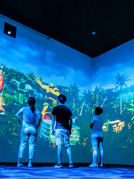 Visitors experience local legends through projection mapping in an immersive room.