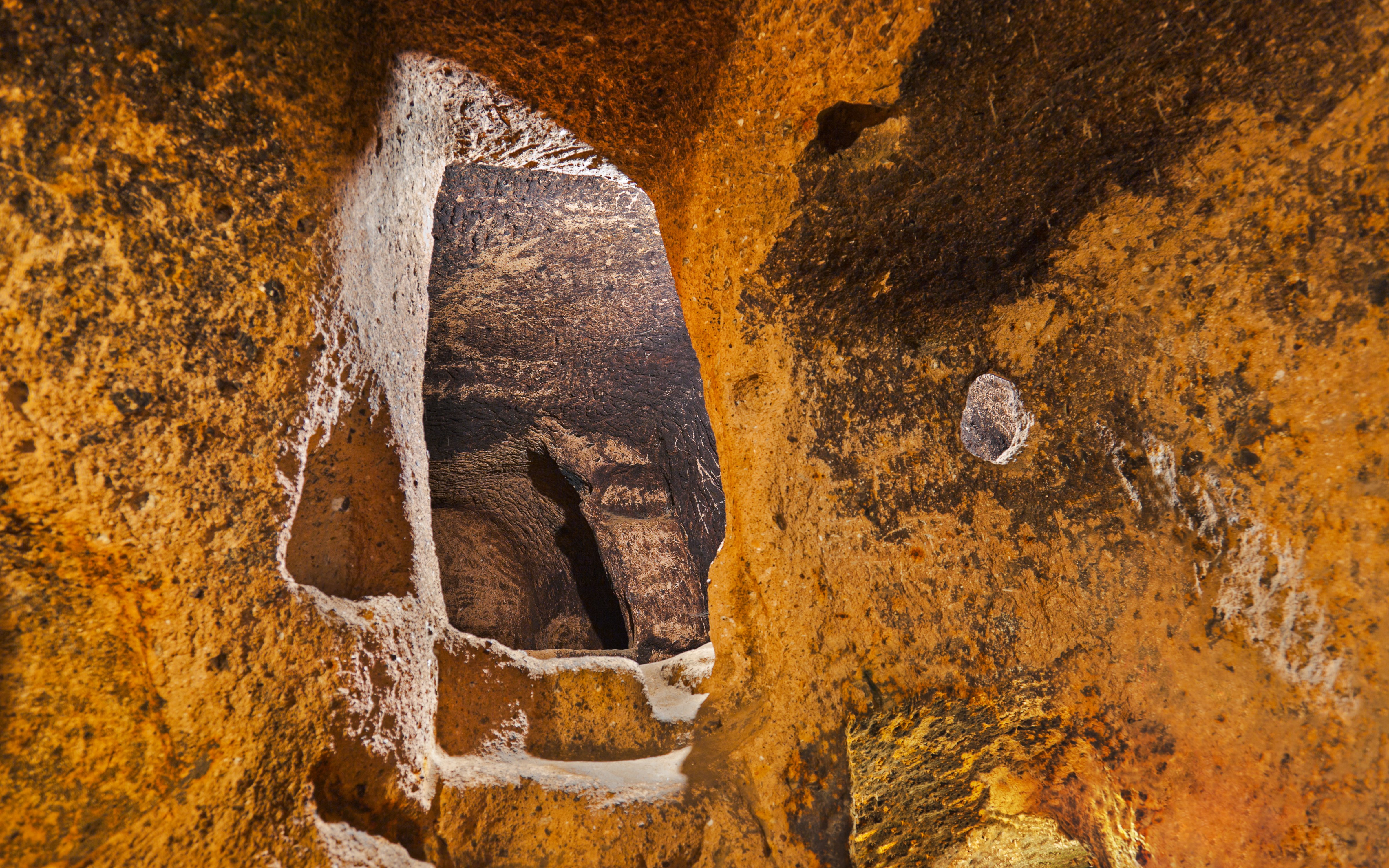 Gaziemir Underground City passageway with carved stone walls, Turkey.