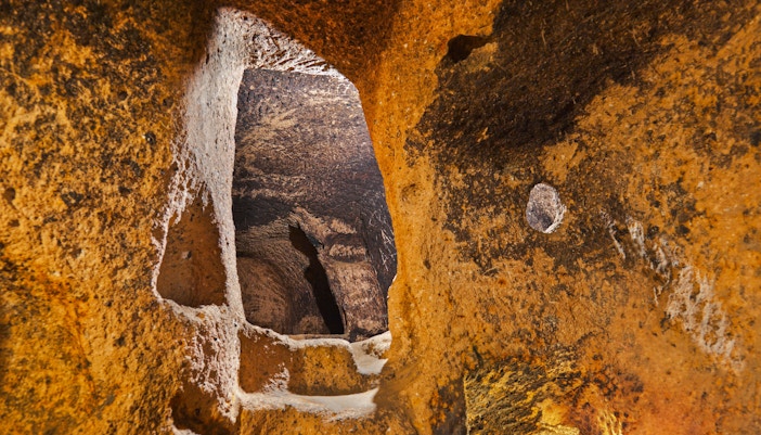 Gaziemir Underground City passageway with carved stone walls, Turkey.