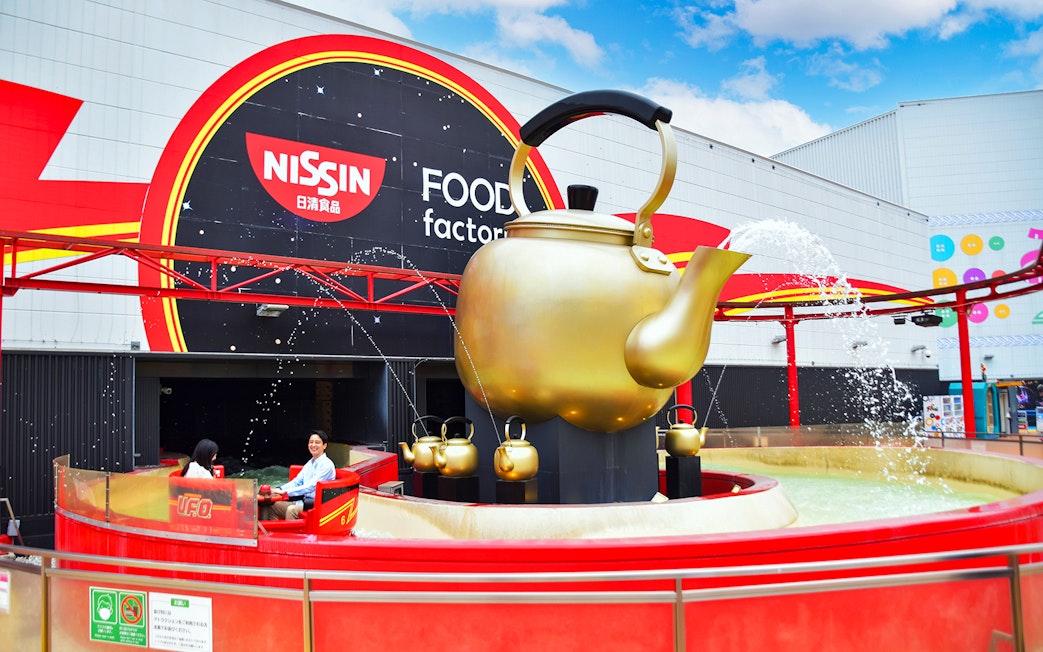 Visitors enjoying a ride at Yomiuriland's Nissin Food Factory attraction.