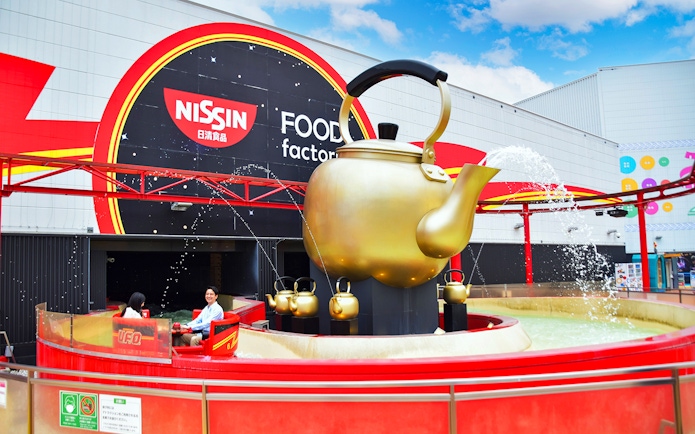Visitors enjoying a ride at Yomiuriland's Nissin Food Factory attraction.
