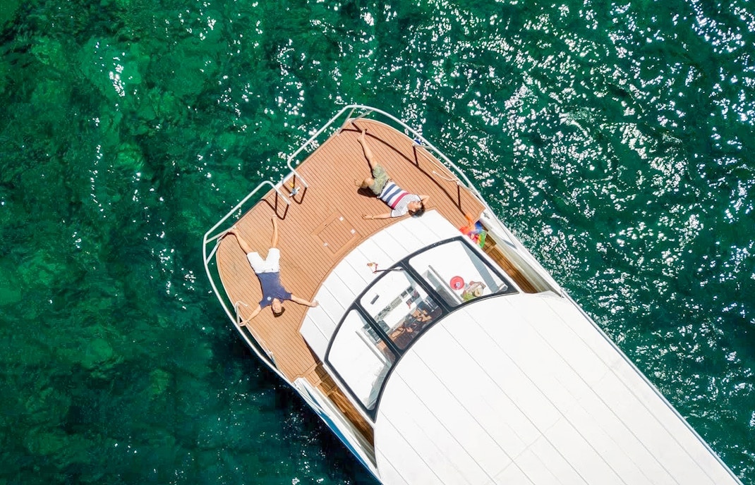 Tourists relaxing on catamaran deck during Phi Phi Islands tour, Phuket, Thailand.
