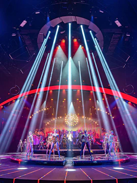 Performers on stage with vibrant lights at ARISE Grand Show.