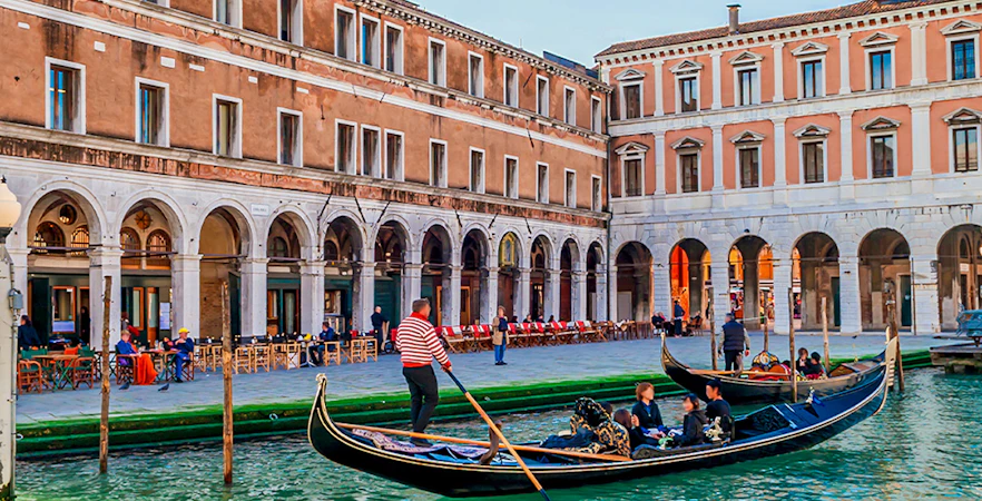 Gondola with passengers on a Venice canal during evening ride.