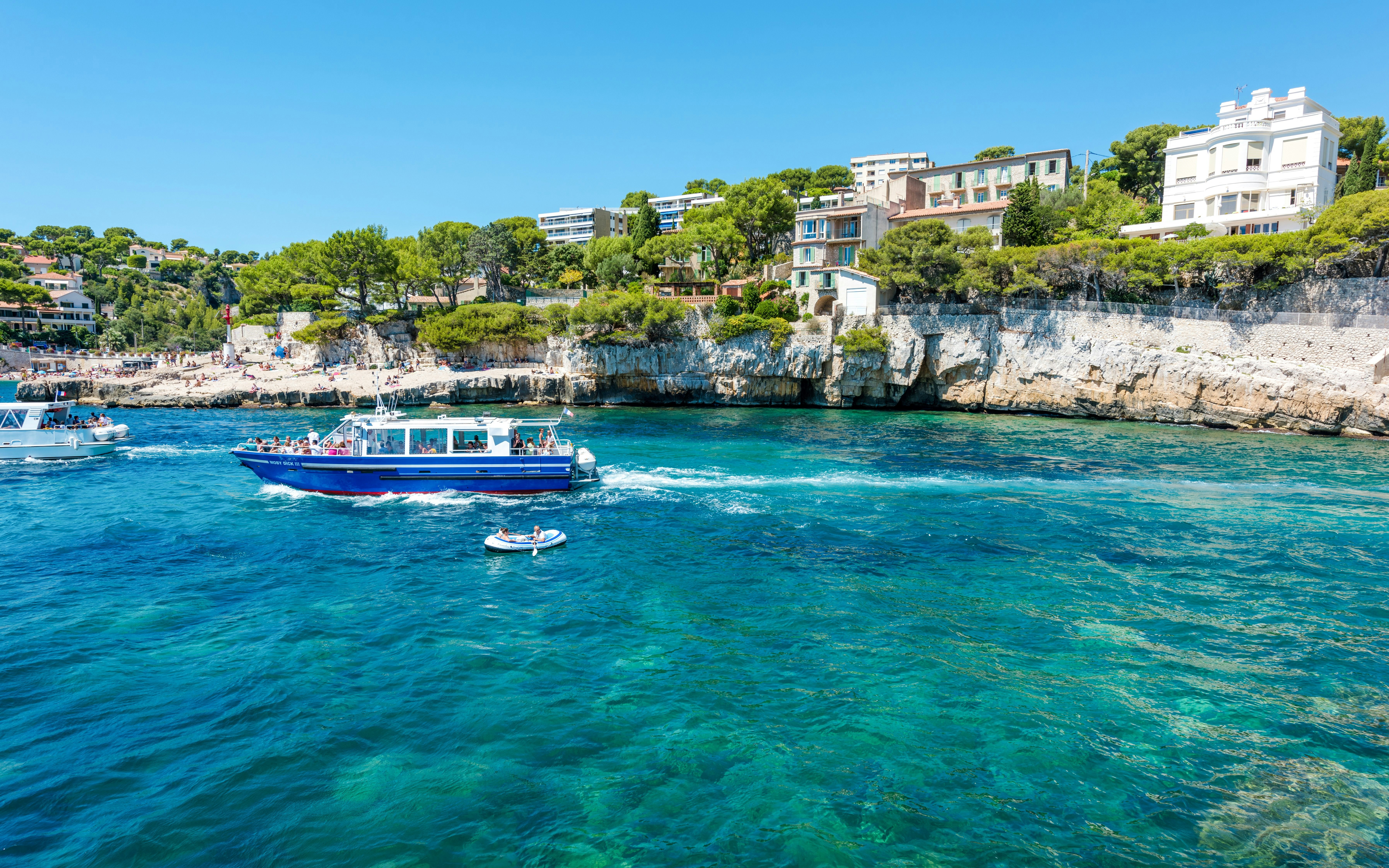Boat tour along the coastline of Cassis, Provence with cliffs and waterfront houses.