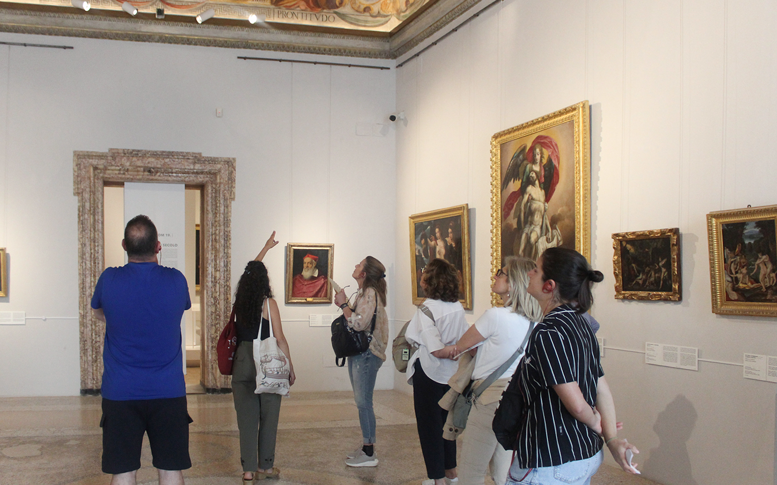 Visitors observing artwork during a guided tour inside Palazzo Barberini, Rome.