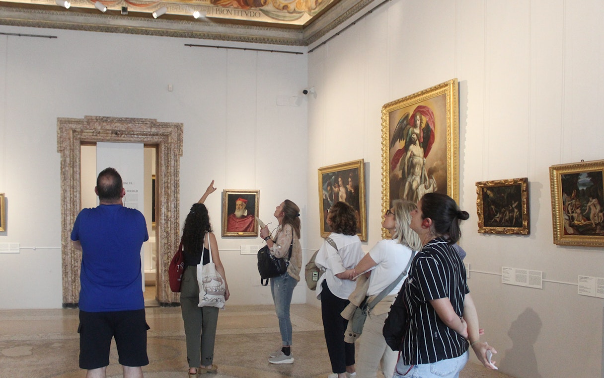 Visitors observing artwork during a guided tour inside Palazzo Barberini, Rome.