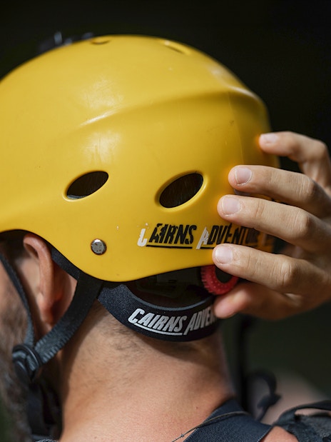 Rafting participant adjusting helmet for Barron River adventure.