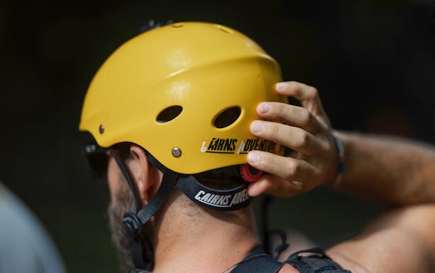 Rafting participant adjusting helmet for Barron River adventure.