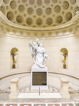 Statue inside Expiatory Chapel with ornate ceiling and wall details, Paris, France.