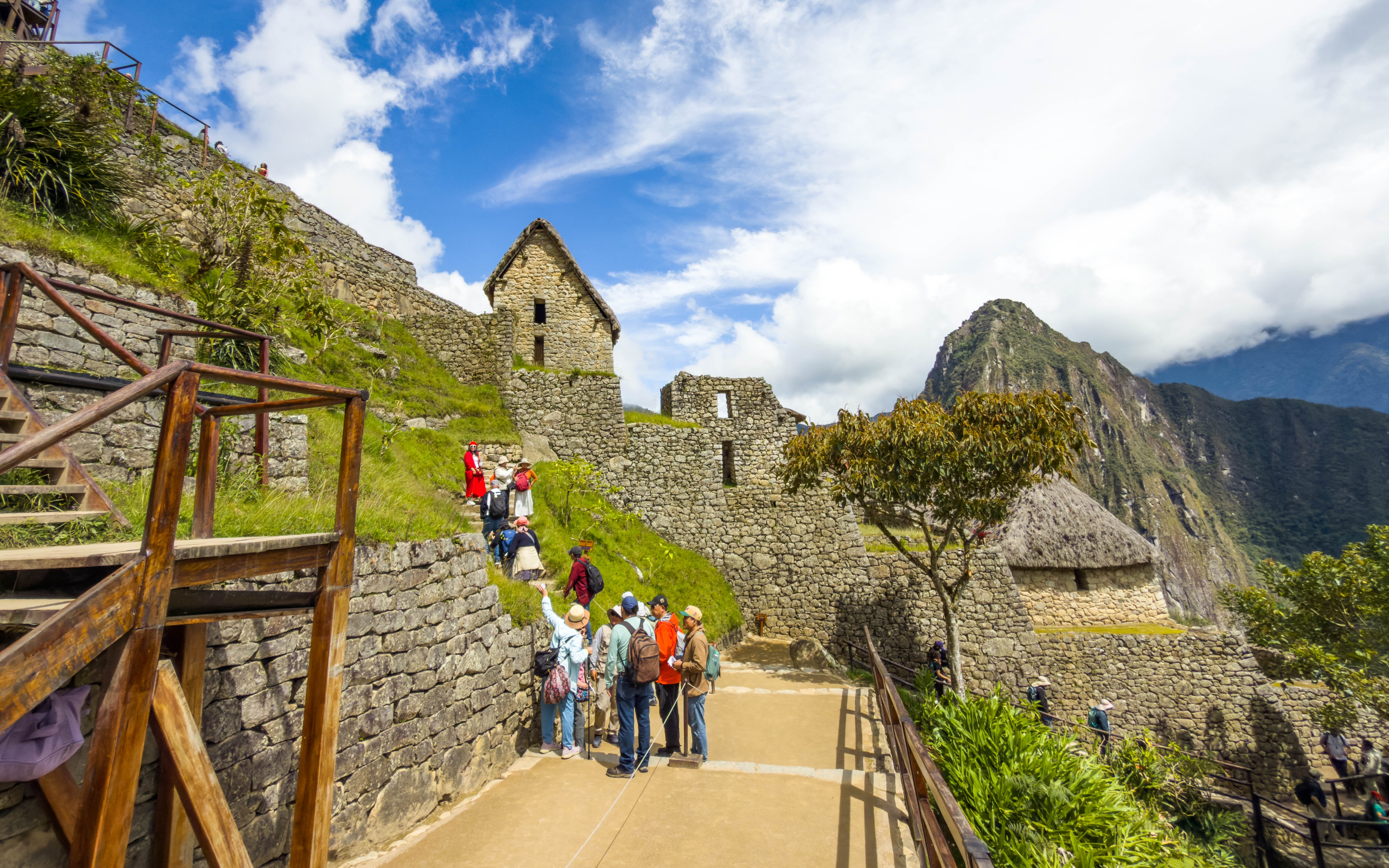 Tourists exploring stone structures at Machu Picchu, Peru.
