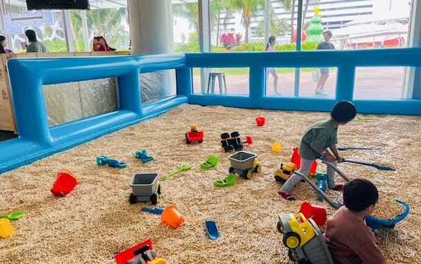 Children playing with toy trucks in a sandpit at Bouncetopia by Kiztopia, VivoCity.