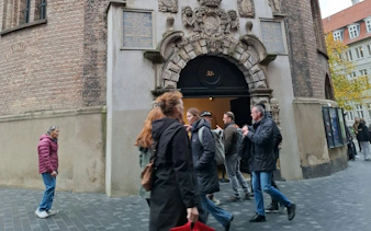 People entering a historic building in Copenhagen during a self-guided city exploration game.