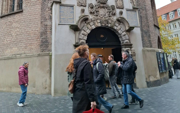 People entering a historic building in Copenhagen during a self-guided city exploration game.