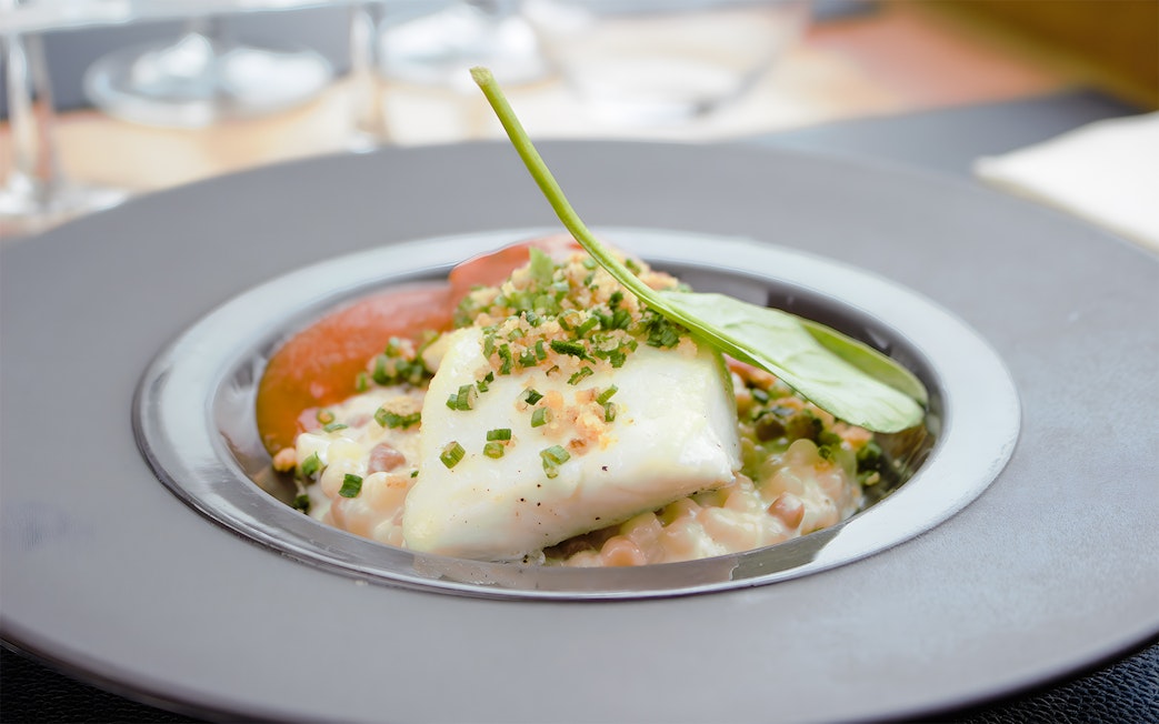 White fish with herbs and vegetables served on Bustronome Paris tour.