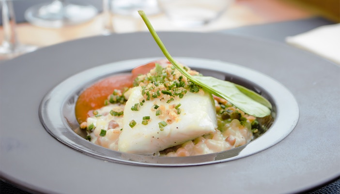 White fish with herbs and vegetables served on Bustronome Paris tour.