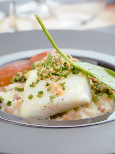White fish with herbs and vegetables served on Bustronome Paris tour.