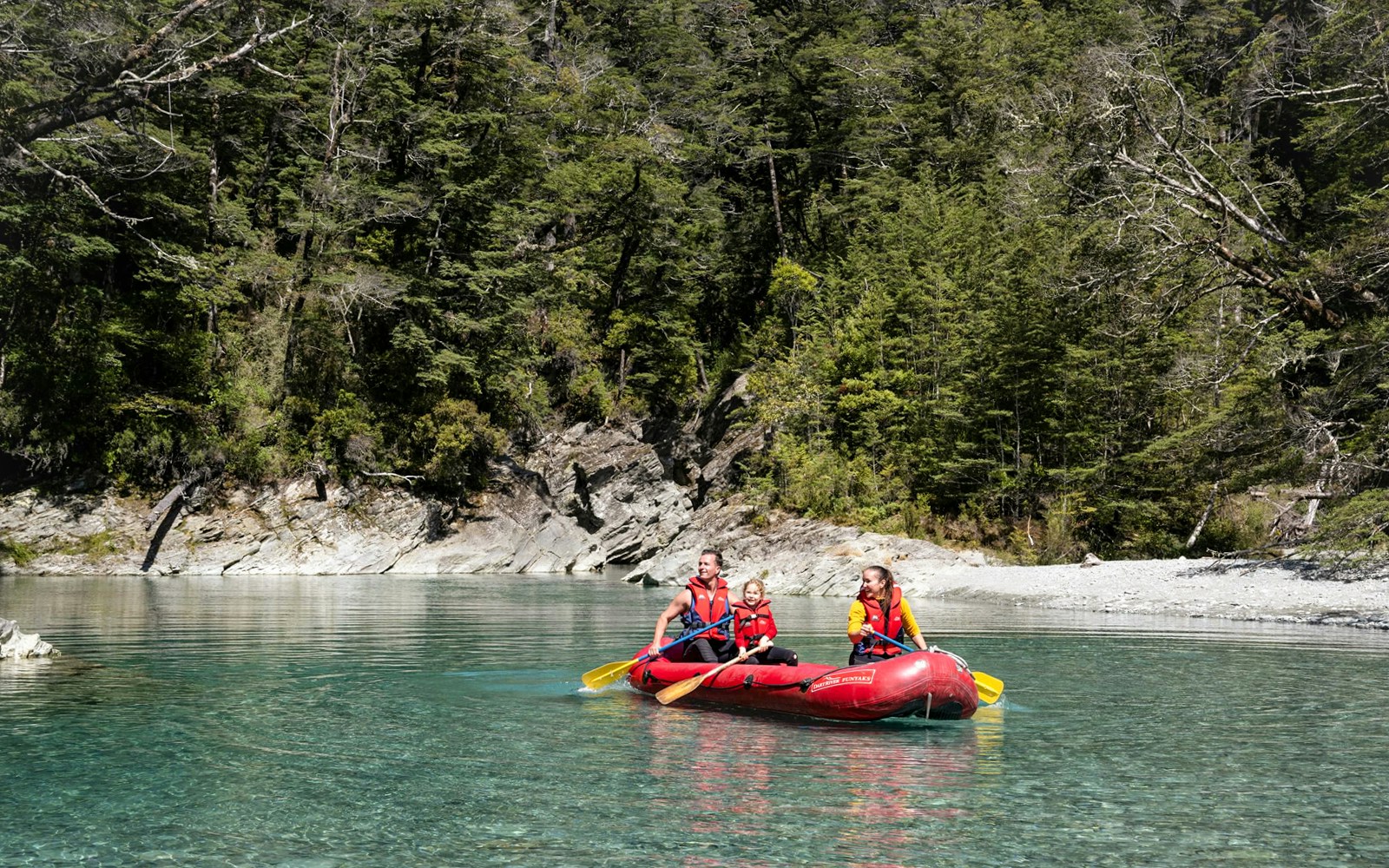Funyak tour on Dart River with lush forest backdrop in New Zealand.