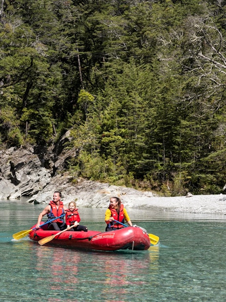 Funyak tour on Dart River with lush forest backdrop in New Zealand.