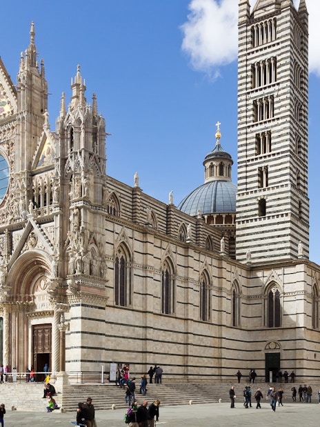 Siena Cathedral facade with visitors in Tuscany, Italy.