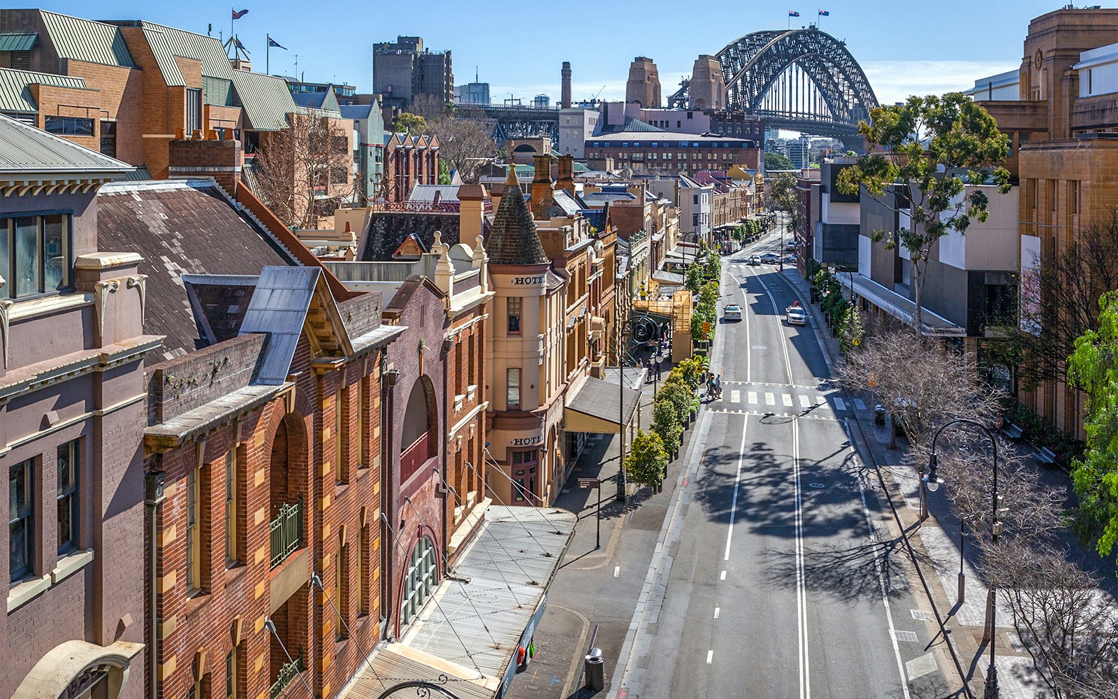 Historic street view in The Rocks, Sydney, with the Sydney Harbour Bridge in the background.