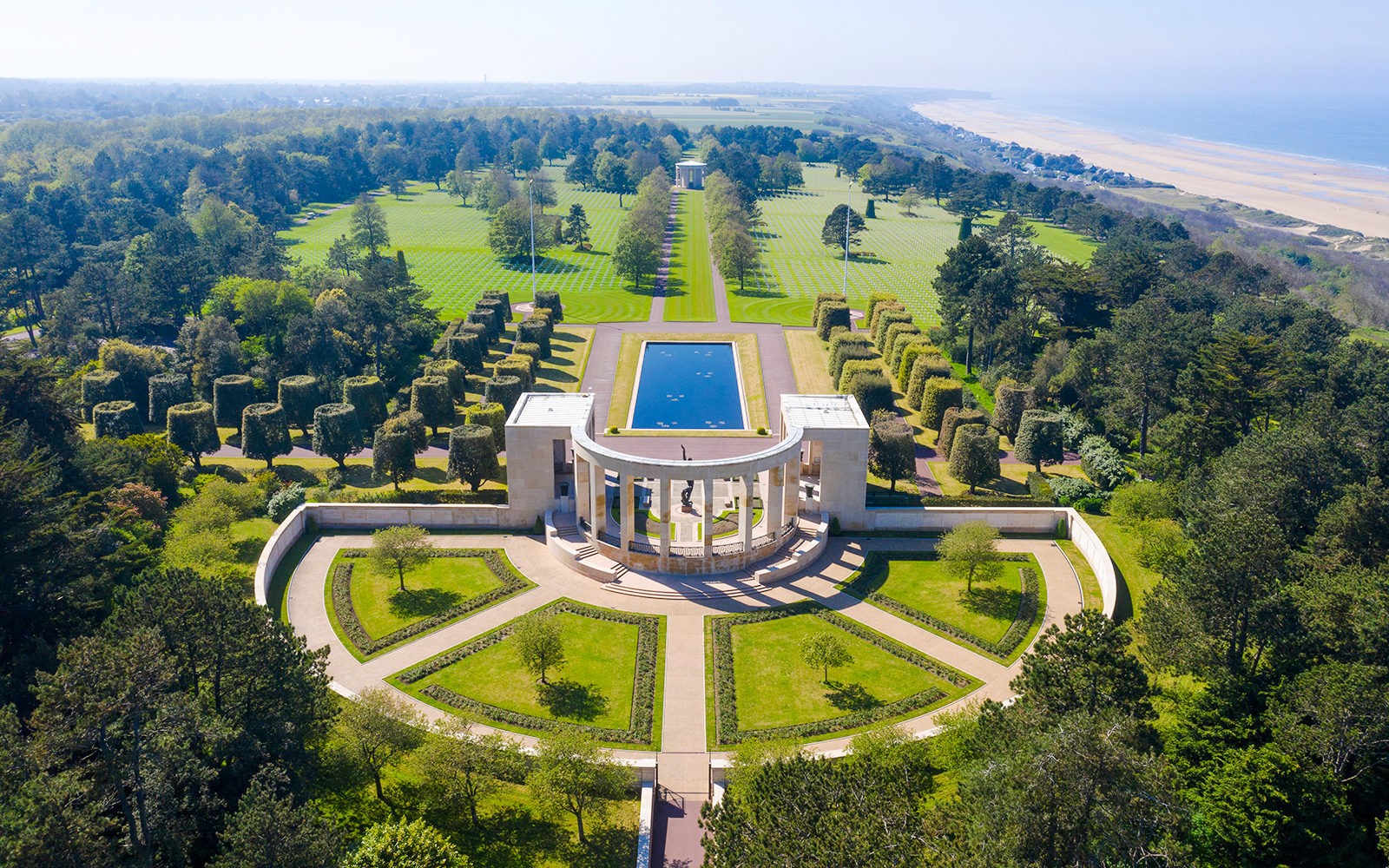 American War Cemetery at Omaha Beach, Normandy, with memorial and aligned graves.