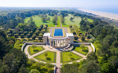 American War Cemetery at Omaha Beach, Normandy, with memorial and aligned graves.