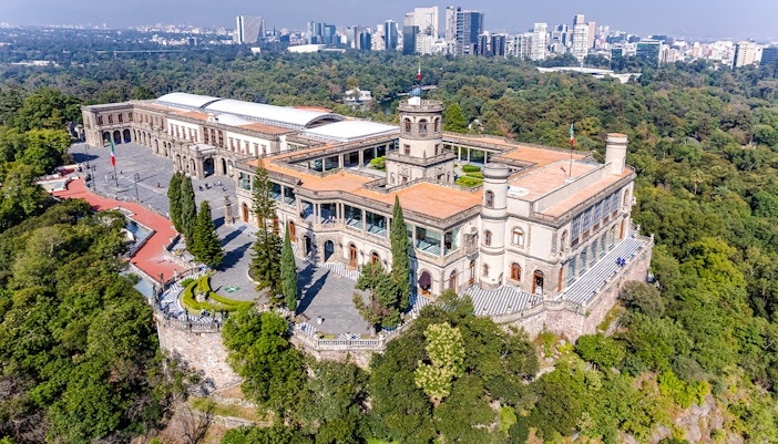 Chapultepec Castle in Mexico City surrounded by lush gardens and historic architecture.