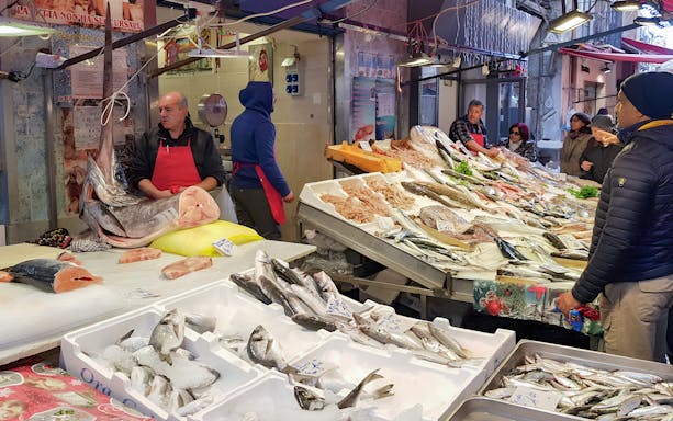 Fish market scene in Palermo with vendors and customers during a half-day guided tour.