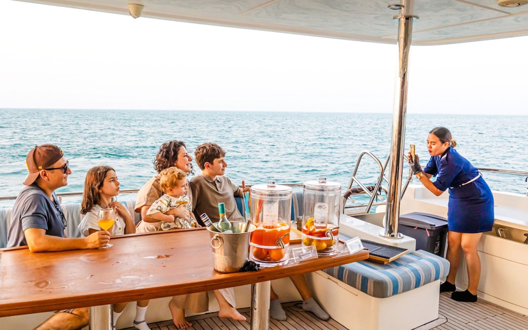 Guide photographing family on yacht cruise, Dubai.