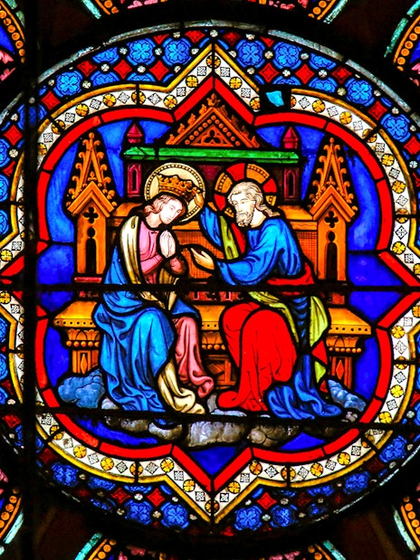 Stained glass window in Notre-Dame Cathedral, Paris, depicting religious figures.