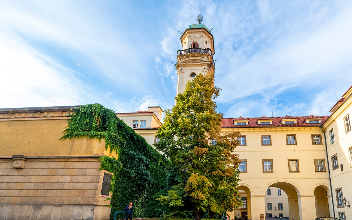 Klementinum courtyard with historic tower and ivy-covered walls in Prague City.