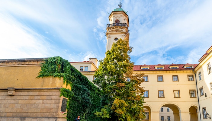 Klementinum courtyard with historic tower and ivy-covered walls in Prague City.
