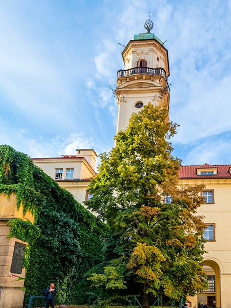 Klementinum courtyard with historic tower and ivy-covered walls in Prague City.