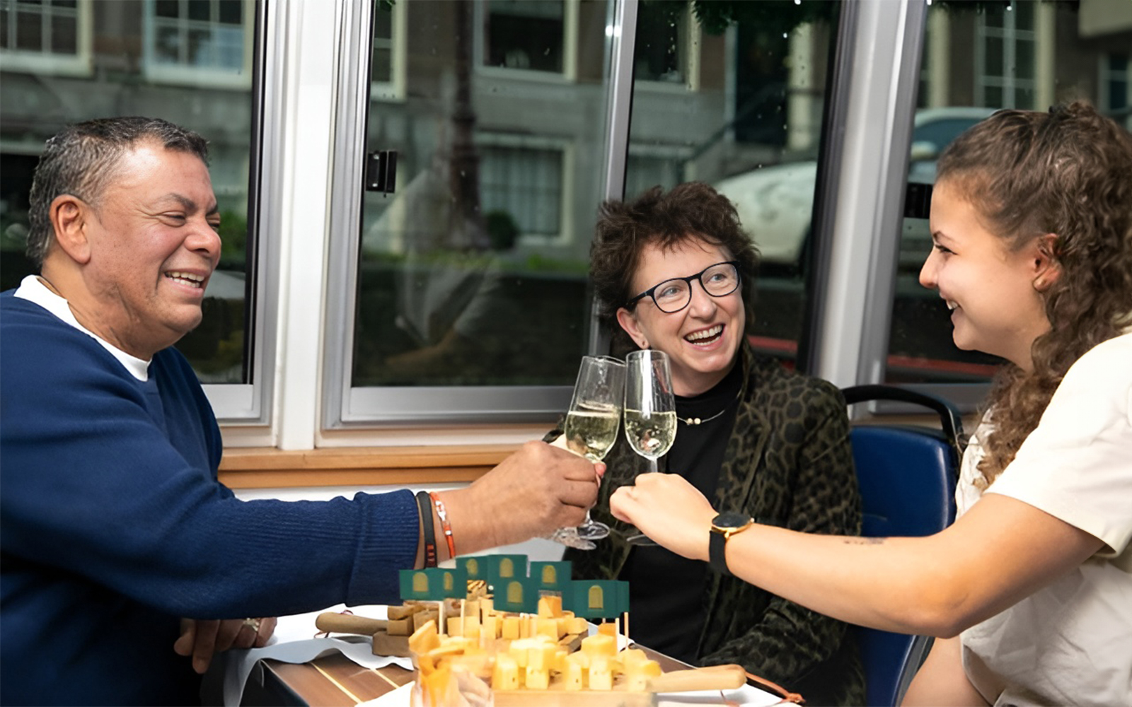 Guests enjoying wine and cheese on an Amsterdam canal cruise.