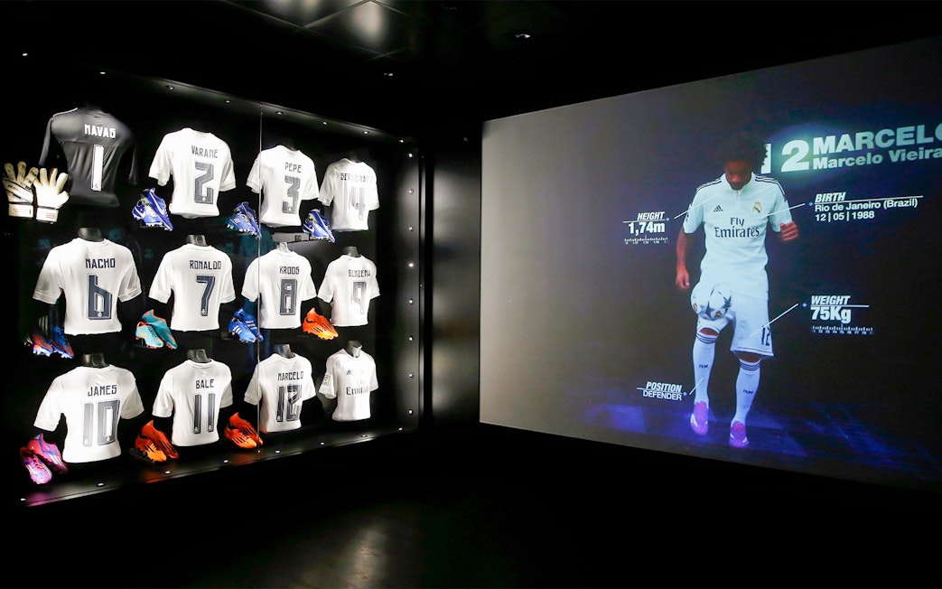 Football jerseys and player stats display at Santiago Bernabéu Stadium tour.
