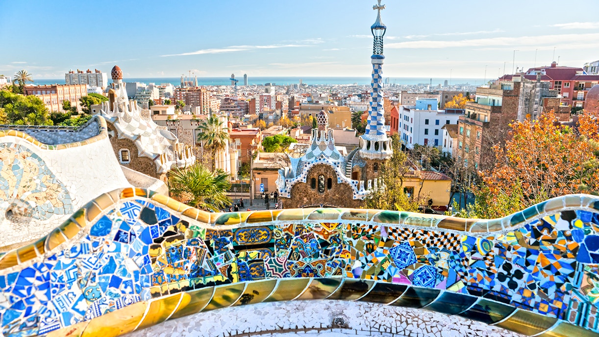 Park Guell panoramic view with colorful mosaic benches and cityscape in Barcelona, Spain.