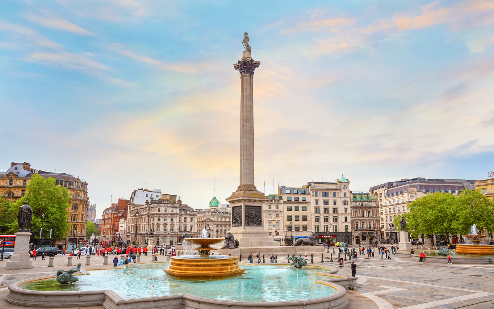 Nelson's Column at Trafalgar Square with fountains and surrounding buildings in London, UK.