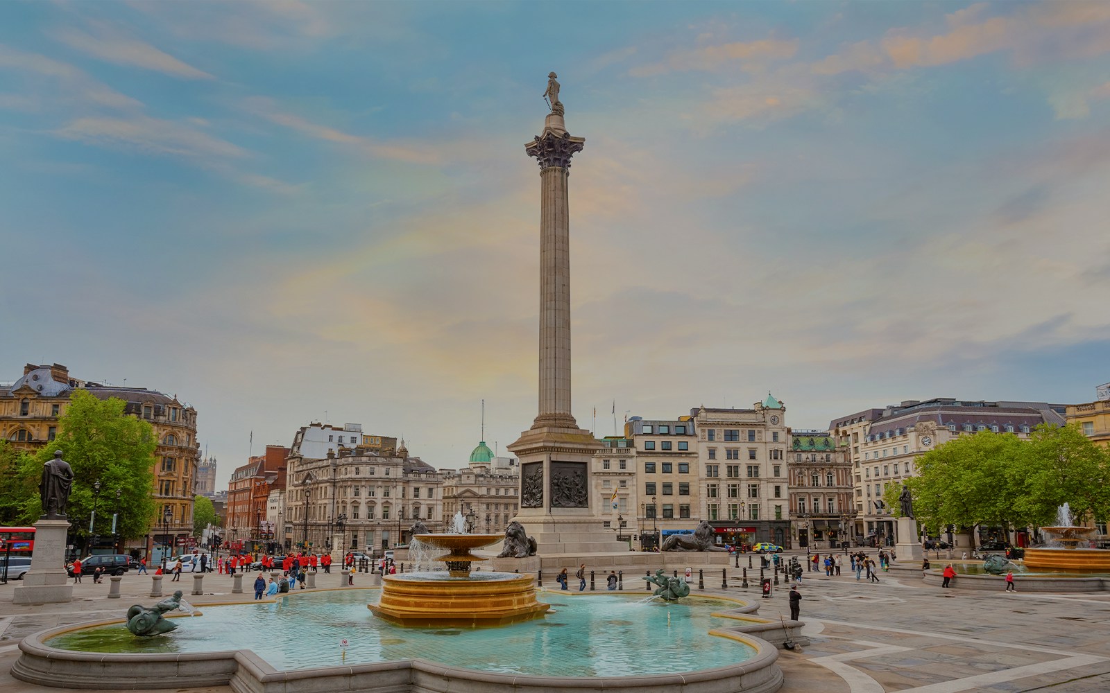 Nelson's Column at Trafalgar Square with fountains and surrounding buildings in London, UK.