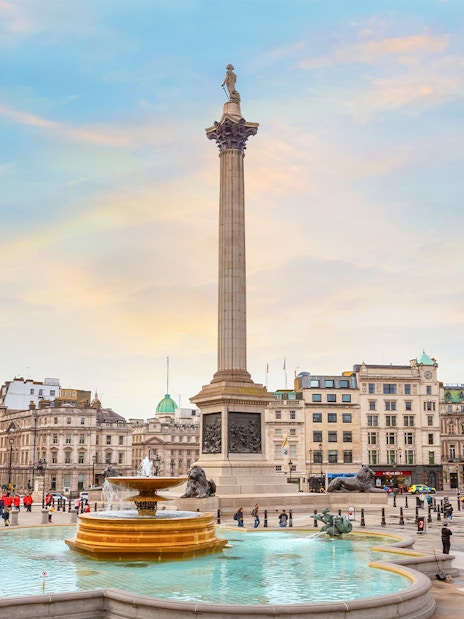 Nelson's Column at Trafalgar Square with fountains and surrounding buildings in London, UK.