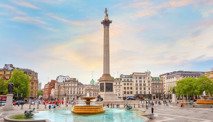 Nelson's Column at Trafalgar Square with fountains and surrounding buildings in London, UK.