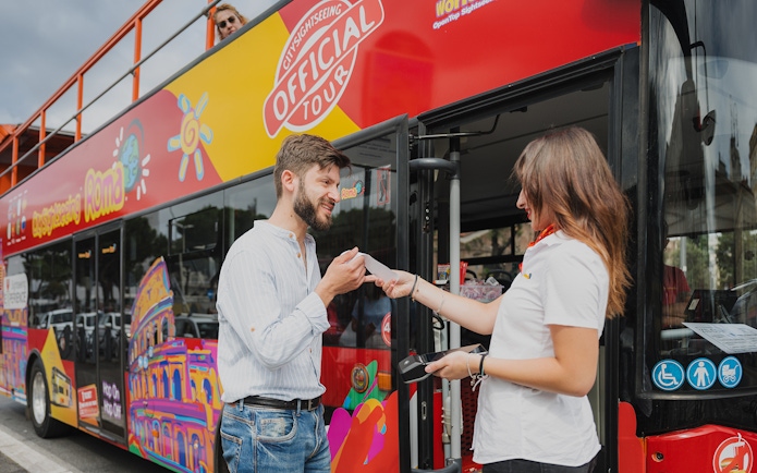 Passenger boarding City Sightseeing bus in Rome, receiving ticket from tour guide.