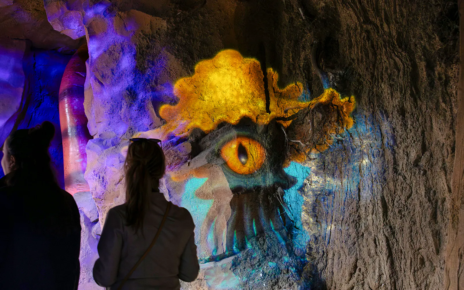 Colorful Halloween-themed cave art at ZooParc de Beauval with visitors observing.