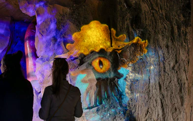 Colorful Halloween-themed cave art at ZooParc de Beauval with visitors observing.