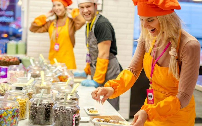 Participants in Vienna chocolate workshop pouring chocolate into mugs.