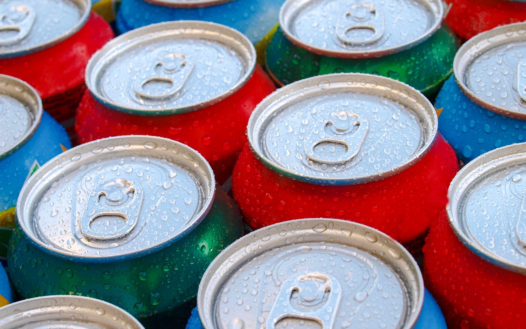 Cold soft drink cans with condensation droplets.